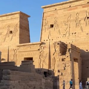 "Visitors exploring Philae Temple in Aswan Egypt during a scenic boat ride on the Nile to Agilkia Island"
